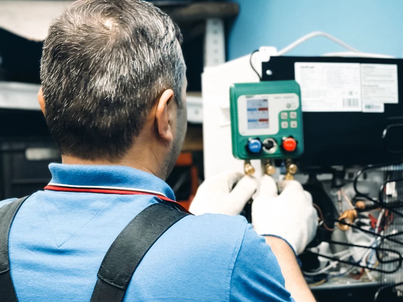 Technician checking refrigerant pressures with a gauge manifold